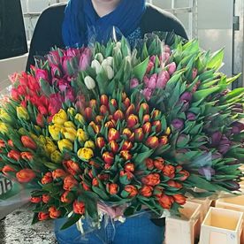bouquet plein de fleurs tenu par un homme